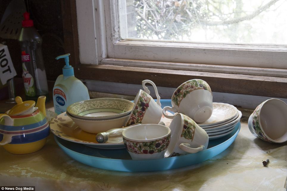 The home is abandoned but little appears to have been done to clean up, with used teacups and cutlery left lying throughout the kitchen